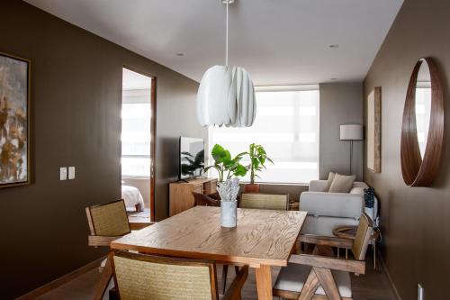 a dining room with a wooden table and chairs at Japandi style apartment in Polanco in Mexico City