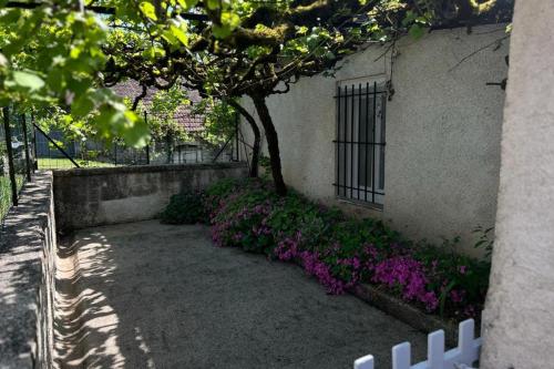 un jardín con flores púrpuras junto a un edificio en Maison de Famille à Soulier, en Gramat
