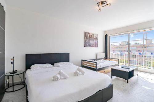 une chambre avec un grand lit et une grande fenêtre dans l'établissement Appartement Clemenceau avec piscine - Welkeys, à Vallauris