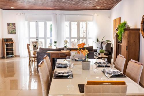 uma sala de jantar com uma mesa longa e cadeiras em Linda casa na Lapa 4 Quartos, Piscina, Churrasqueira e Jardim em São Paulo