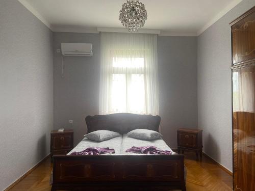 1 dormitorio con 1 cama con 2 almohadas y ventana en Luka Family Guest House en Batumi