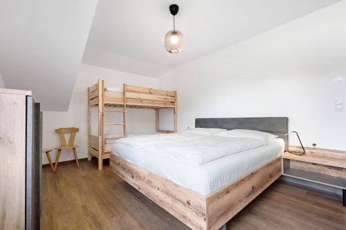 een slaapkamer met een groot bed en een houten ladder bij Haus Mader 2 in Riscone