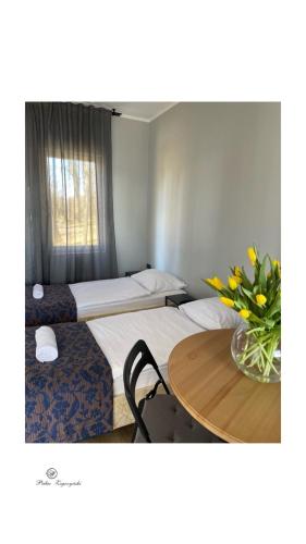 a hotel room with two beds and a table with flowers at Pałac Zegrzyński in Zegrze