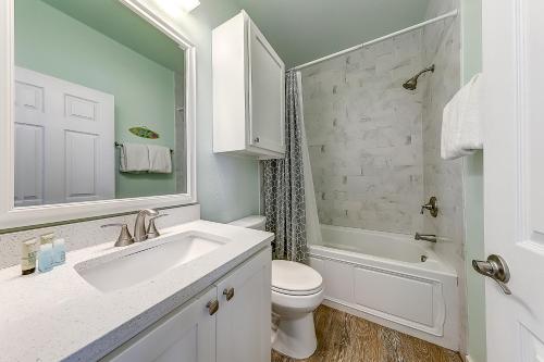Un baño blanco con lavabo e inodoro. en Eskridge Gem Unit B, en Port Aransas