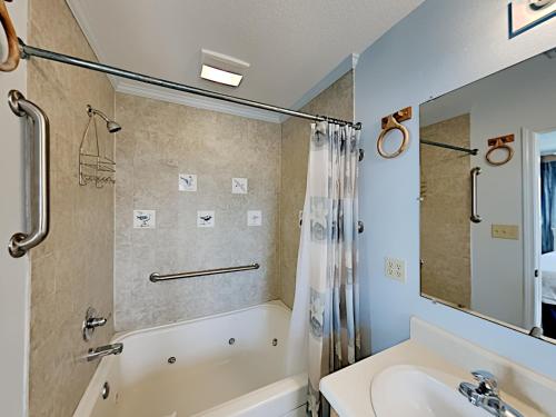 a bathroom with a tub and a sink at Sea'Scape in Pensacola Beach