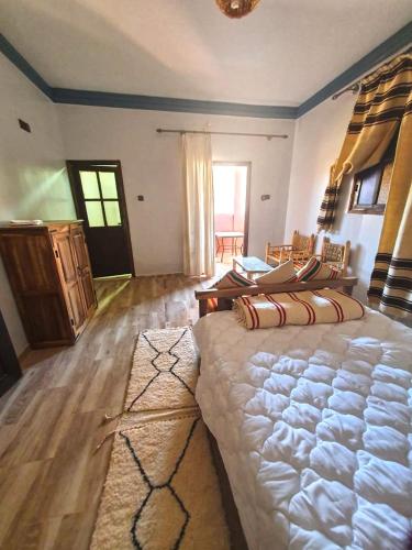 um quarto com uma cama grande num quarto em La Perle d'adassil 