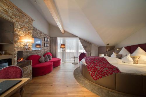 a hotel room with a large bed and a fireplace at Hotel Das Rübezahl in Schwangau