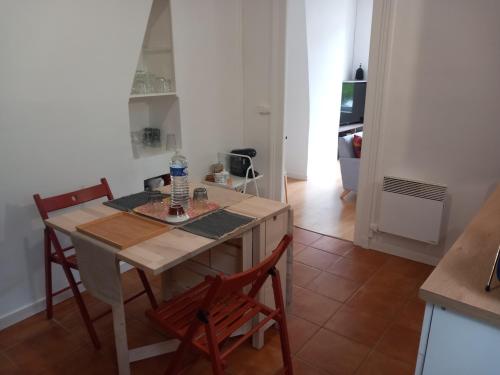 uma cozinha com mesa e cadeiras num quarto em Le Léon em Honfleur