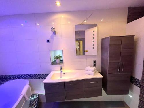 une salle de bain avec un lavabo, un miroir et une baignoire dans l'établissement Spacious apartment in the heart of the center, à Riquewihr