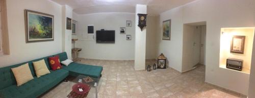 uma sala de estar com um sofá verde e uma televisão em Casa Mersini em Chania Town