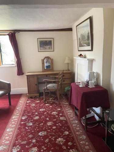 a room with a desk and a table with a chair at Gilberts End Farm in Great Malvern