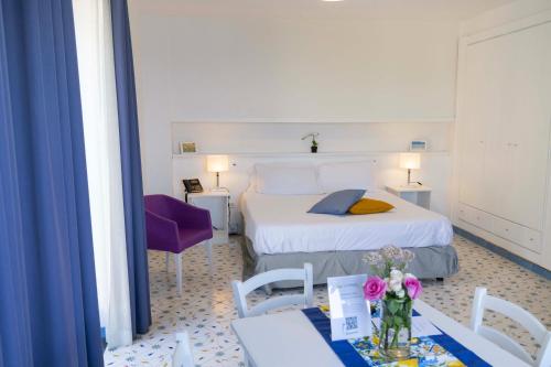 a hotel room with a bed and a table and chairs at Cala Moresca Apartments in Bacoli