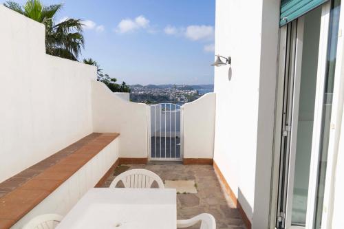 a balcony with a table and chairs and a view of the ocean at Cala Moresca Apartments in Bacoli