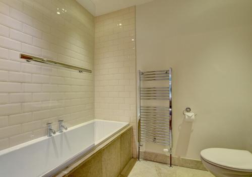 een witte badkamer met een bad en een toilet bij River Cottage in Lynmouth