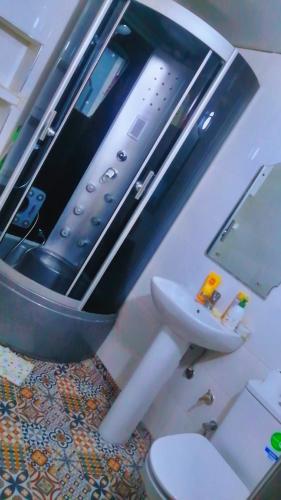 uma casa de banho com uma televisão por cima de um WC e um lavatório em Bab aissi home em Meknès
