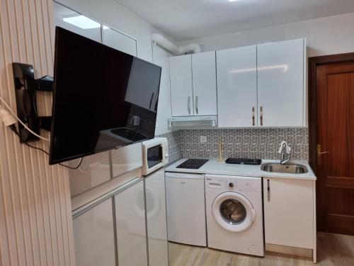 a kitchen with a washing machine and a tv at Estudio Brisa del Poniente Aguadulce in Aguadulce