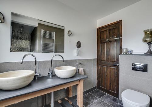 ein Badezimmer mit zwei Waschbecken und einem WC. in der Unterkunft Rock House in Ilfracombe
