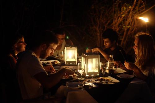 a group of people sitting at a table in the dark at Big Game - Wilpattu by Eco Team in Wilpattu