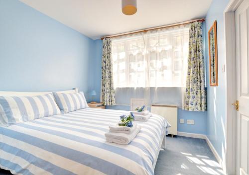 a blue bedroom with a bed with towels on it at River View in Lynmouth