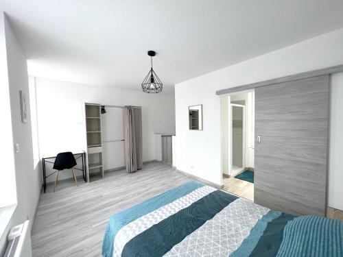 Habitación blanca con cama y escritorio en 180A - Duplex T2 Tout Confort du Gond - 45 m2, en Le Gond-Pontouvre