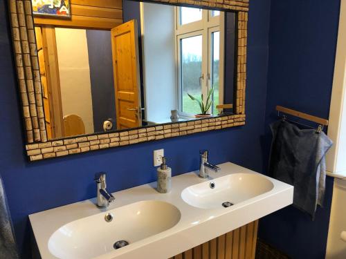 ein Badezimmer mit einem weißen Waschbecken und einem Spiegel in der Unterkunft La Ola in Hanstholm