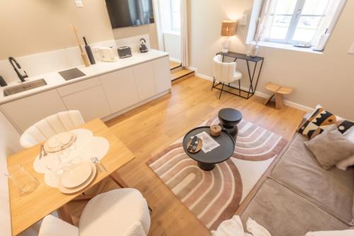 een woonkamer en een keuken met een tafel bij Le Boho . Centre-ville Mâcon . Proche gare . Design . Neuf . Wifi . Climatisation . Confort in Mâcon