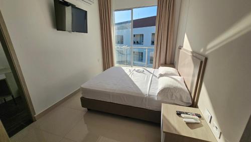 a bedroom with a bed and a large window at Hotel Santa Sofia in Puerto Salgar