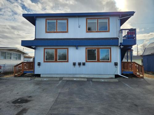 a blue house with windows on a parking lot at Nightshade BnB in Anchorage