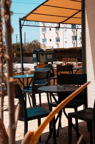 a patio with tables and chairs with an umbrella at Olive Island in Larnaka
