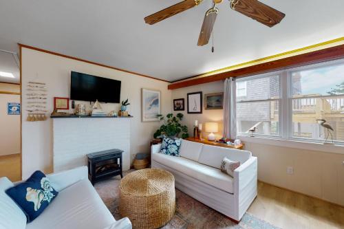 a living room with a white couch and a tv at Sea Shanty 960 in Hatteras