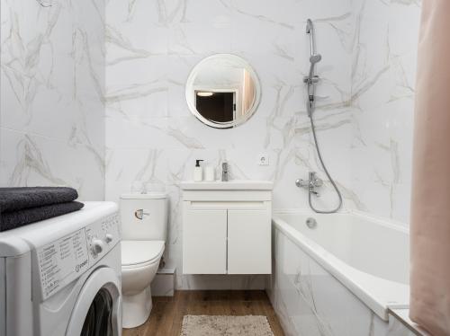 uma casa de banho branca com uma máquina de lavar roupa e um lavatório em 0157 Сучасні нові апартаменти ЖК Щасливий em Kiev