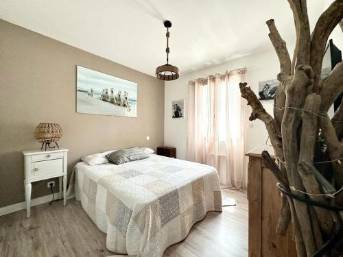 - une chambre avec un lit et un arbre dans l'établissement Mas LOUIS II, à Vauvert