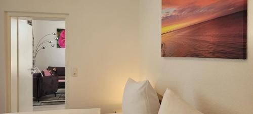 a bedroom with a painting on the wall and a couch at Ferienwohnungen Stranddistel - Apartments von 30 bis 75 qm in Zinnowitz