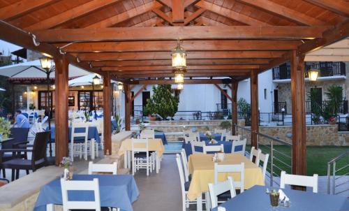 a restaurant with blue tables and white chairs at Ledra Maleme Hotel in Maleme