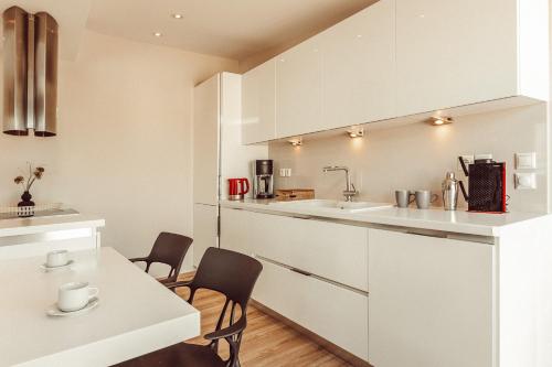 een keuken met witte kasten en een tafel en stoelen bij Suitas in Athene