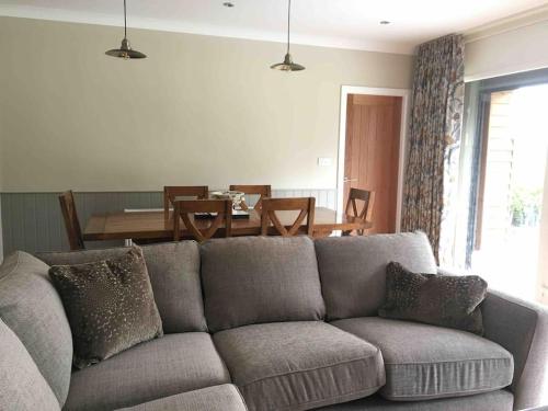 a living room with a gray couch and a table at The Mistal@Cow Close Barn, Leyburn - Relax, and Enjoy in Leyburn