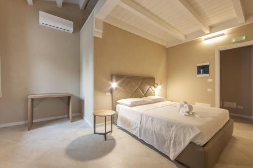 a bedroom with a large bed and a table at Relais Borgo Camisa in Castiadas