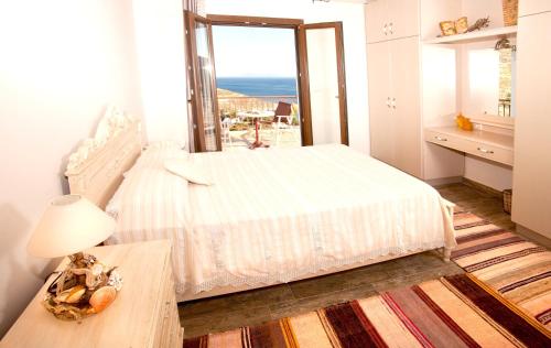 3 bedrooms house at Kalymnos 350 m away from the beach with sea view enclosed garden and wifi في كاليمنوس: غرفة نوم مع سرير وإطلالة على المحيط