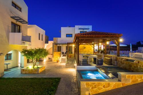 una casa con piscina por la noche en Ledra Maleme Hotel, en Máleme