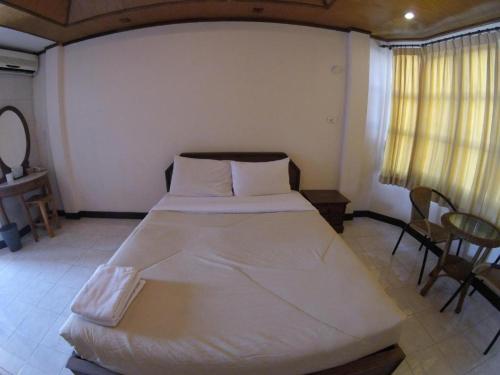 a bedroom with a large white bed in a room at Kraisaeng Place in Phitsanulok