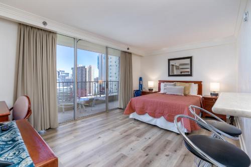 a hotel room with a bed and a balcony at Royal Garden Waikiki - Wyndham Resort in Honolulu