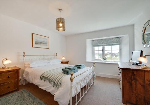 a bedroom with a bed and a desk and a television at Sunnymead in Barnstaple