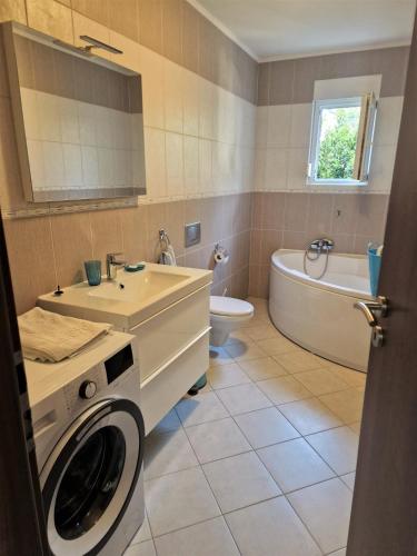 a bathroom with a washing machine and a sink at Villa Petra in Rab