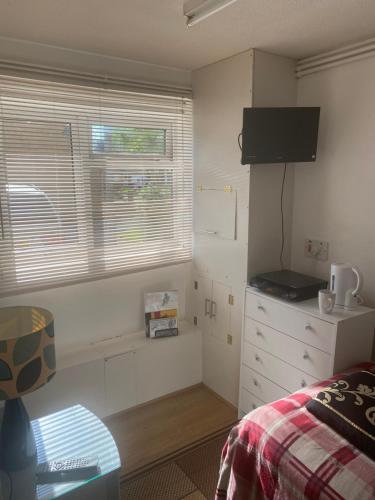 a bedroom with a bed and a tv on a wall at Travelling Stop in Swindon