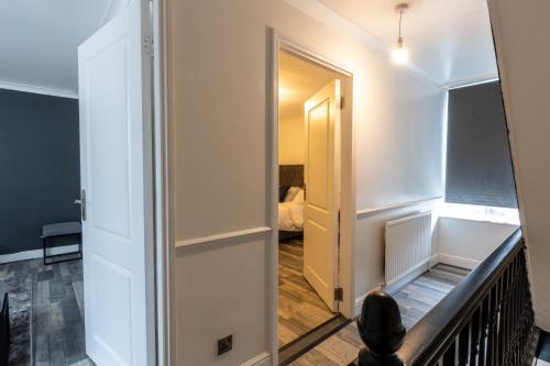 een hal die leidt naar een kamer met een spiegel bij The Stratford Victoria in Londen