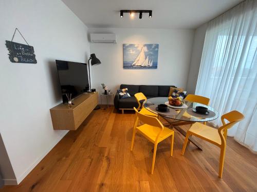 een woonkamer met een tafel en stoelen en een bank bij Luxury apartment Mon Soleil in Murter