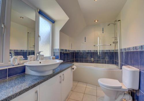 uma casa de banho com um lavatório, um WC e uma banheira em Sundowner em Croyde