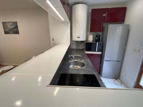 - une cuisine avec un évier au milieu dans l'établissement Appartement cosy F2, à Creil