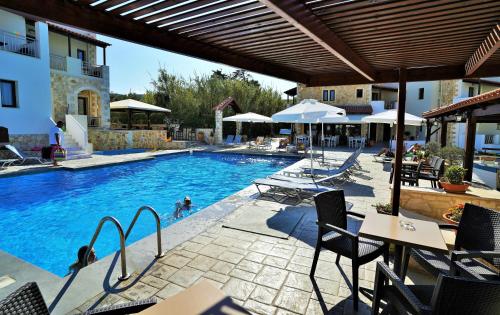 a swimming pool with chairs and tables and umbrellas at Ledra Maleme Hotel in Maleme