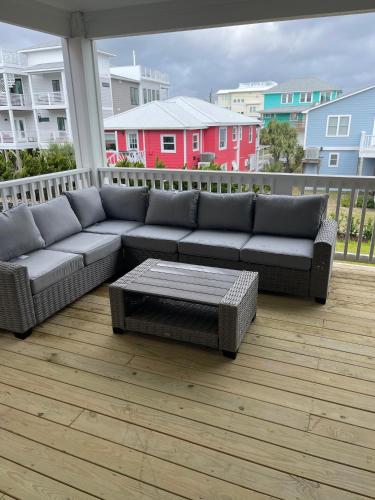 a couch and a coffee table on a balcony at Swanky Seahorse in Carolina Beach